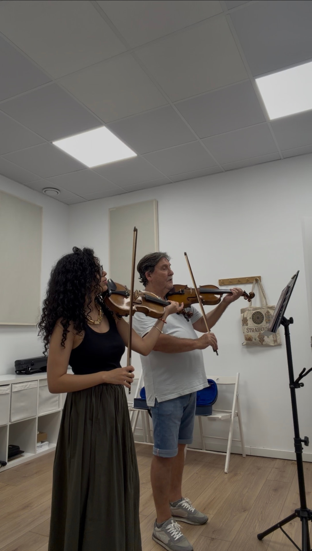 Profesora y alumno tocando el violín juntos en clase
